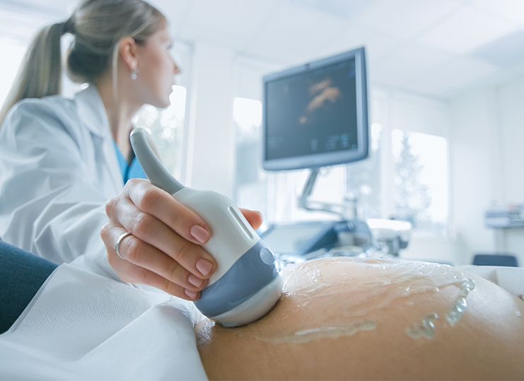 An ultrasound examination performed on a pregnant woman by a doctor.